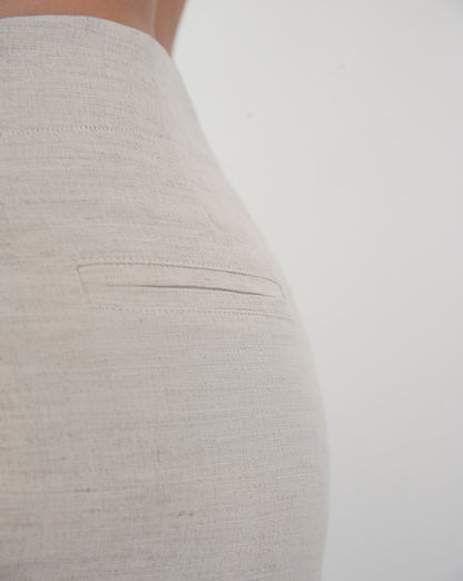 Dipped low waist kick-flare trousers in nude linen. Inseam slit with zip fastening.